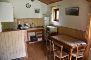 a kitchen with a wooden table and a refrigerator at Les Chalets du Roc in Alzon