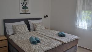 a bed with two blue pillows on it at Zelena oaza in Krk