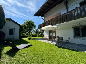 a patio with an umbrella and a table and chairs at Wohnung mit Garten am See in Langenargen