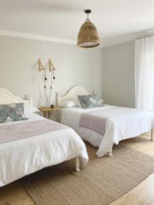 a bedroom with two beds and a pendant at O VIOLAS - Art Coffee & Guesthouse in Praia de Mira