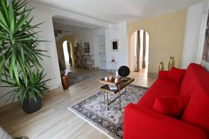ein Wohnzimmer mit einem roten Sofa und einem Tisch in der Unterkunft La perla di Asti con Jacuzzi e Sauna in Asti