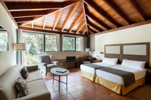 un dormitorio con una cama y un sofá en Parador de Cruz de Tejeda, en Tejeda