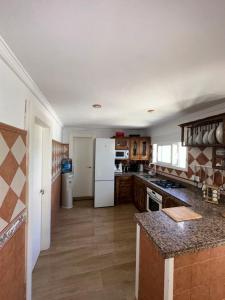 a kitchen with a white refrigerator and wooden floors at House Beach in Bolonia