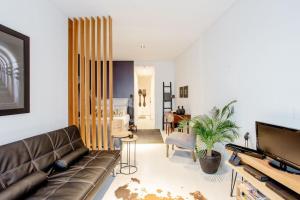 a living room with a couch and a television at Alcântara Lodge in Lisbon