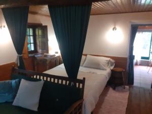 a bedroom with a bed with blue drapes at Casa da Avó Maria na Quinta do Castro in Manhuncelos +24 photos