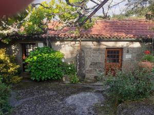 an old stone house with a red roof at Casa da Avó Maria na Quinta do Castro in Manhuncelos