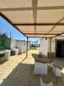 a picnic table under a large umbrella on a patio at House Beach in Bolonia