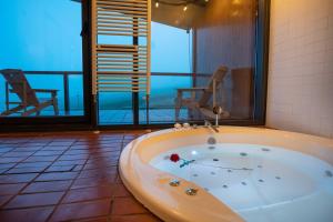 een bad in een kamer met een balkon bij Suites Niditas in Yuso +75 foto's