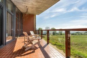 een veranda met 2 stoelen en uitzicht op een veld bij Suites Niditas in Yuso
