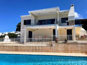 ein Haus mit einem Swimmingpool davor in der Unterkunft Panoramic Seacave Cottage in Peyia