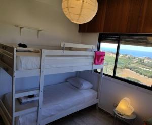 ein Schlafzimmer mit zwei Etagenbetten und einem Fenster in der Unterkunft Panoramic Seacave Cottage in Peyia + 37 Fotos