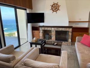 ein Wohnzimmer mit Couch und Kamin in der Unterkunft Panoramic Seacave Cottage in Peyia