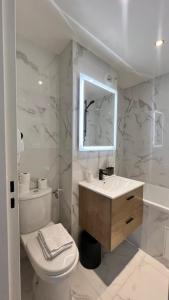 a bathroom with a toilet and a sink and a mirror at Hôtel Lebron in Paris