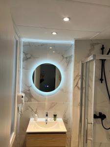 ein Badezimmer mit Waschbecken und Spiegel in der Unterkunft Hôtel Lebron in Paris