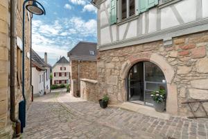 an alley with an archway in a stone building at Das Alte Pfarrhaus Galerie in Gleisweiler