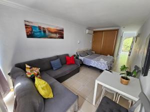 een woonkamer met een bank en een bed bij Apartamento Florido in Torremolinos