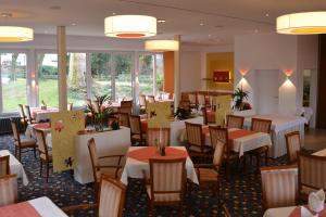 een eetkamer met tafels, stoelen en ramen bij Hotel Zur Mühle in Bad Breisig