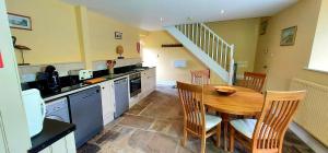 a kitchen and dining room with a table and chairs at Edensor Cottage Bakewell Peak District in Bakewell