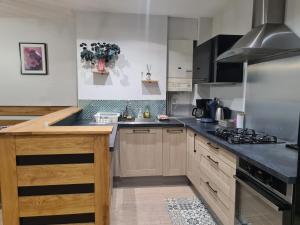 a kitchen with wooden cabinets and a stove top oven at Appartement hyper-centre Issoire in Issoire