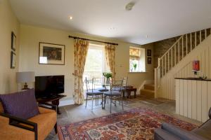a living room with a tv and a table and chairs at Edensor Cottage Bakewell Peak District in Bakewell