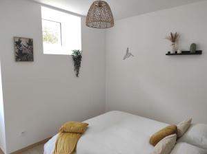 una camera da letto bianca con un letto e un divano di 2-Le Tropical - Jaccuzi - Sarlat - Centre ville a Sarlat-la-Canéda