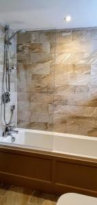 ein Badezimmer mit Badewanne und Dusche in der Unterkunft Dunsa Cottage Bakewell Peak District in Bakewell