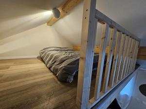 a bed in a small room with a staircase at O'Pains d'Epices in Horbourg