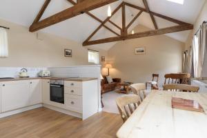 a kitchen and living room with a table and chairs at Heron Cottage Upperdale Peak District in Buxton