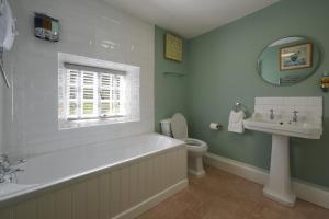 une salle de bain avec une baignoire, un lavabo et des toilettes dans l'établissement Riversdale Farm Cottage Upperdale Peak District, à Buxton