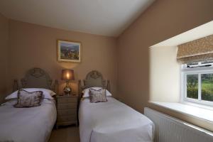 une chambre avec deux lits et une fenêtre dans l'établissement Riversdale Farm Cottage Upperdale Peak District, à Buxton