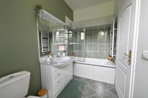 a bathroom with a sink and a tub and a toilet at Villa MANSART in Ver-sur-Launette +25 photos