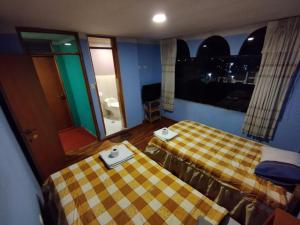 a hotel room with two beds and a window at Backpackers 3b Titikaka Treking in Puno +2 photos