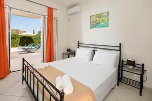 una camera da letto con un letto grande e un balcone di Villa Anamari Eos Villas ad Ágios Stéfanos Altre 41 foto