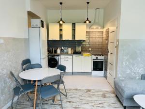 a kitchen and living room with a table and chairs at Apartament ogrodowy in Miechów