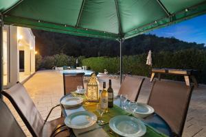 un tavolo con piatti e bottiglie di vino su un patio di Villa Anamari Eos Villas ad Ágios Stéfanos