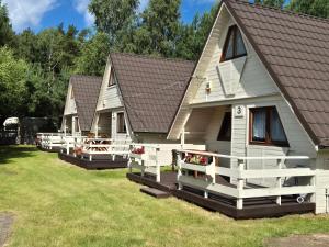 a row of cottages parked in the grass at Domki Letniskowe Bryza in Jarosławiec