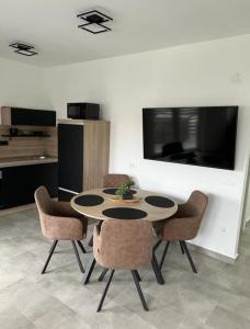 a table and chairs in a room with a kitchen at Apartmani Frane in Vir