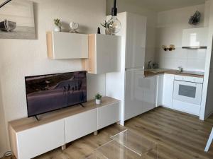a living room with a tv and a kitchen at Hossegor Vue Océan in Soorts-Hossegor