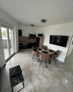 a living room with a table and chairs and a television at Apartmani Frane in Vir +84 photos