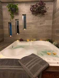 baño con bañera y 2 copas de vino en Casa Grande con Jacuzzi cerca de ctra MochisTopo, en Los Mochis