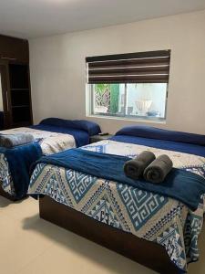 Un dormitorio con dos camas y una ventana. en Casa Grande con Jacuzzi cerca de ctra MochisTopo, en Los Mochis