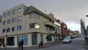a building on the corner of a street with cars parked at Skólavörðustígur Apartments in Reykjavík