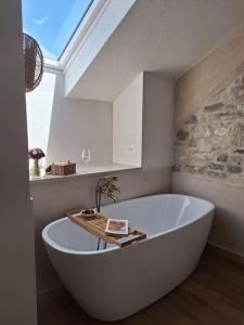 a large white tub in a bathroom with a window at Stone house Gazda in Omiš +32 photos