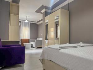 a bedroom with a bed and a purple chair at Kalmuk Apartment Hotel in Trabzon