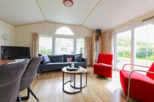 a living room with a blue couch and red chairs at Camping Heino in Heino