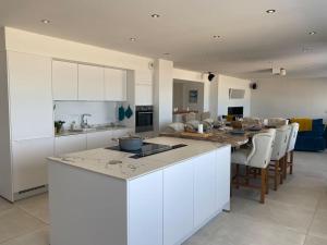 eine Küche und ein Wohnzimmer mit Tisch und Stühlen in der Unterkunft La Plage in Donville-les-Bains