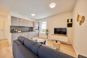 a living room with a blue couch and a kitchen at HomeME 1 I zentral I NETFLIX I Küche I Parkplatz I kliniknah in Bad Oeynhausen