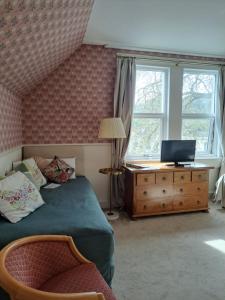 a bedroom with a bed and a dresser with a television at Avon Guesthouse in Bath