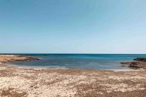 a beach with the ocean in the background at Villa delle Lantane San Lorenzo Marzamemi in San Lorenzo