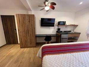 une chambre avec un lit et un bureau avec une télévision dans l'établissement Dk4-Studio for 4 in Zona Viva, à Guatemala